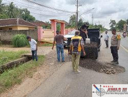 Bhabinkamtibmas Polsek Abung Selatan Bersama Warga Timbun Jalan Berlubang di Jalinsum Bandar Kagungan Raya
