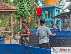 Babinsa Larangan Bantu Warga Berikan Pakan Ternak Ikan Lele